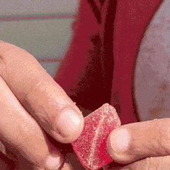 Looping gif of a person splitting a gummy in half with the perforation
